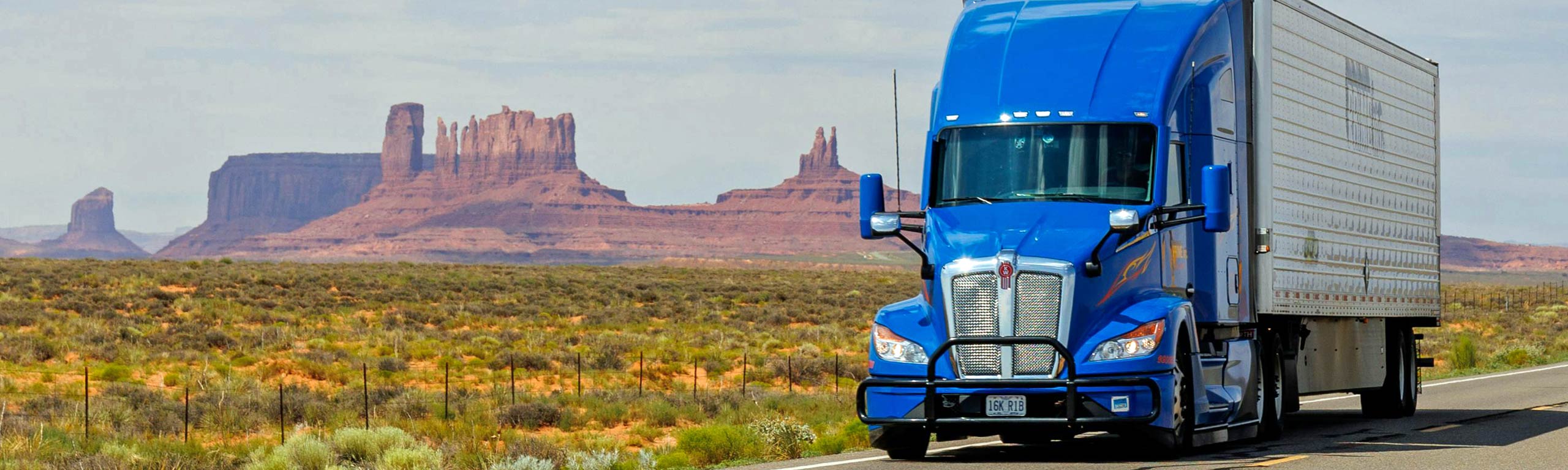transportation recruiters, trucking recruiters. blue semi rig crossing the US mid west.